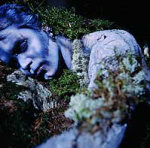 Ruoska-bändin jäsen makaa naama sinisenä ja mustelmilla silmät ummessa pöpelikössä.