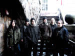 Rapture-bändin miehet, joita kuvassa kuusi kappaletta, seisovat rivissä ulkoilmassa. Heillä yllään lämpimät talvivaatteet. Heidän takanaan näkyy portaita ja vasemmassa laidassa kiviseinää tai –muuria. Oikeassa yläkulmassa kuva on palanut puhki