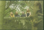 Vihreäsävyinen promovalokuva nelihenkisestä Mourning Beloveth -bändistä, johon kuuluu vain miehiä. Heistä kaikilla pitkät tai puolipitkät hiukset. Miehet seisovat rivissä luonnn helmassa suurien puiden ympäröimänä.