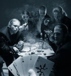 Codeon-yhtyeen miehistö pelaa kylmähkönoloisessa ryhmäpotretissa pokeria. Kuva on utuinen, savuinen. Pokerimiehiä taustalla viisi kappaletta. Lähes kaikki osoittavat kohtisuoraan tuliaseilla.