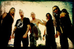 Five Finger Death Punch -bändin pressivalokuva, jossa yhtyeen viisi hevimiestä seisovat rivissä. Kaikilla heillä mustat vaatteet yllään. Osalla pitkät hiukset. Keskimmäisellä miehellä ei ole paitaa yllään ja hänellä kalju pää. Kuva on laidoista mustaksi n