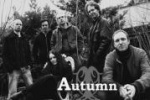 Harmaasävyinen valokuva Autumn-bändin kokoonpanosta, jonka jäsenet seisovat ulkoilmassa puiden edustalla. Kuvassa viisi miestä, joiden keskellä istuu mustiin pukeutunut pitkähiuksinen nainen. Bändin nimi lukee valkoisella värillä kuvan alaosassa keskitett