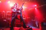 Valokuva Children Of Bodomin jäsenestä soittamassa kitaraa tai bassokitaraa punaisten spottivalojen säihkeessä.