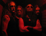 Hämärä ja punasävyinen valokuva Marduk-yhtyeen neljästä miehestä, jotka ovat kaikki corpse maskeihin naamansa sotkeneita ja pitkähiuksisia.