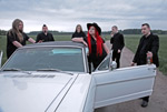 Embassy of Silencen promokuva. Kuvassa yhtyeen jäsenet kerääntyneet auton ympärille. Keskimmäisenä seisoo punatukkainen Ines Lukkanen. Kaikilla jäsenillä mustat palttoot.