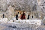 Ryhmäkuva Whyzdom-yhtyeen jäsenistä seisomassa rivissä suunnattoman suurta kallioseinää vasten. Jäsenet ovat pääosin mustiin pukeutuneita.