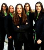 Vision Divine -yhtyeen jäsenet seisovat rivissä yllään mustat puvut, mutta vihreät kauluspaidat. Keskimmäisellä miehellä on pitkät kiharat hiukset, yllään musta puku (ilman vihreää kauluspaitaa). Kuvan tausta on valkoinen.