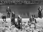 Mustavalkoinen promokuva Catamenia-bändin miehistöstä, jonka muodostaa kuusi miestä. Kuvassa he seisovat veden äärellä kivikossa. Kuvan vasemmassa yläkulmassa bändin logo.
