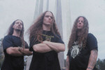 Hate Eternal -yhtyeen jäsenet, eli kolme pitkähiuksista miestä, seisovat sumuisassa säässä ulkoilmassa. Taustalla jonkinlainen taideteos tai pylväs. Miehillä mustat t-paidat.