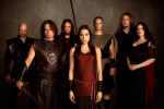 Battlelore-bändin jäsenet seisovat ryhmänä nuhjuista, ruskeanväristä seinää vasten. Kuvassa seitsemän henkilöä, joista kaksi on naisia. Keskimmäisellä naisella punainen hame tai mekko, joka on tehty kiiltävästä kankaasta.