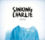 Vaalea tausta, jonka päällä valokuva sinisestä paidasta, jonka yllä lukee mustalla Sinking Charlie ja "Shelter".