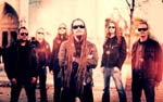 Ylivalottunut ryhmäkuva Amorphis-yhtyeen kokoonpanosta, jonka jäsenistä jokaisella on mustat aurinkolasit silmillä.