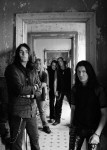 Mustavalkoinen promokuva To/Die/For-bändin jäsenistä, jotka seisovat sisätiloissa, ovensuussa. Kuvassa viisi miestä, joista jokaisella pitkät hiukset. Osa miehistä pukeutunut mustiin vaatteisiin.