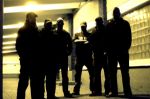 Total Devastation -ryhmittymän jäsenet, joita kuvassa kuusi kappaletta, seisovat autohallissa tai muussa tunnelissa, jonka valaistus kirkkaankeltainen. Miehet seisovat taustavaloa vasten, joten heistä näkyy vain mustat siluetit.