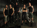Ryhmäkuva metalliyhtye Tuonen kokoonpanosta, johon kuuluu viisi miestä seisomassa synkässä tunnelissa.