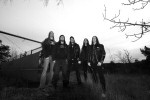 Mustavalkoinen ryhmäpotretti Opeth-yhtyeen kokoonpanosta joitakin vuosia sitten. Kuvassa viisi miestä, jotka seisovat tiiviissä rivissä luonnon helmassa. Maassa on nurmikkoa, kuvan oikeassa laidassa risujen oksia.