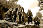 Viisipäisen Iced Earth -yhtyeen jäsenet seisovat rivissä luonnon helmassa. Kuvan värisävyt lähes mustavalkoiset, mutta ruskeahtavat. Viidellä miehistä pitkät hiuskset. Heillä kaikilla nahkavaatteet yllään.