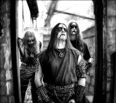 Mustavalkoinen promokuva Enthroned-bändin kolmihenkisestä kokoonpanosta, joka muodostuu black metal -asuihin ja maskeihin sonnustautuneista pitkähiuksisista miehistä.