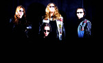 De Lirium's Order -ryhmän neljä jäsentä seisoo mustaa taustaa vasten, mustuus lähes nielaisee heidät. Heistä jokaisella mustat aurinkolasit silmillä. Miehillä pitkät hiukset ja kasarihevivaatteet yllään.