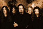 Viisi tummanpuhuvaa mieshahmoa seisoo ruskeasävyisessä valokuvassa. Tämä on Evergrey-bändin kokoonpano vuodelta 2006. Hevimiehiä.