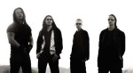 Neljä Winds-ryhmän jäsentä mustavalkoisessa valokuvassa. Miehet seisovat rivissä kirkasta valkoista taustaa vasten. Miehillä pääsääntöisesti kaikki vaatteet tummia tai mustia. Kolmella heistä mustat aurinkolasit silmillä. Vasemmassa laidassa seisoo Hellha