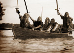 Turisas-bändin viisi miespuolista viikinkiasuihin sonnustautunutta metallisoturia seilaa pienessä veneessä vetten keskellä. Miehet pitävät miekkojaan kohti taivasta ja karjuvat.