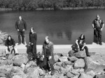 Mustavalkoinen bändikuva Catamenian kokoonpanosta, johon kuuluu kuusi miestä. He seisovat (osa myös istuu) keskellä joen vartta kivikossa. Joen toisella puolella näkyy lehtimetsää. Miehet pukeutuneet pääosin mustiin vaatteisiin.
