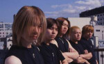 Blood Stain Child -yhtyeen viisi japanilaista jäsentä seisoo rivissä kaupungin näkyessä heidän takanaan. Etummaisena vasemmalla mies, jolla vaaleanruskeat hiukset kammattu kasvojen eteen.