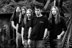 Mustavalkoinen valokuva Lamb Of God -yhtyeen riveistä, johon kuuluu yhteensä viisi miestä. Heistä neljällä pitkät hiukset, yhdellä lyhyt mustanvärinen tukka. Jokaisella heistä yllään musta t-paita ja farkkutyyliset housut.