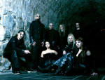 Sinisävyinen valokuva Therion-yhtyeen jäsenistä, joista osa istuu ja osa seisoo suurehkon luolan seinän vierustalla. Valtaosa hahmoista pukeutunut mustiin vaatteisiin. Kuvassa kahdeksan ihmistä, joista kaksi naisia.