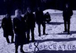 Exsecratus-ryhmän jäsenet seisovat tummasävyisessä valokuvassa lumisessa maastossa. Heistä jokainen pukeutunut mustiin vaatteisiin. Bändin logo kuvan oikeassa alakulmassa.