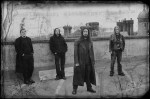 Mustavalkoinen promokuva Desolation-bändin nelihenkisestä kokoonpanosta, joka seisoo jonkinlaisen talon katolla. He ovat miehiä, heistä kolmella pitkät hiukset, kaikilla yllään mustat tai tummat vaatteet. Taustalla näkyy muita rakennuksia.