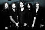 Tummasävyinen ryhmäkuva Evergrey-bändin joukosta, johon kuuluu viisi mustiin pukeutunutta pitkähiuksista miestä. Osalla heistä käsivarret tatuointien peitsossa, osalla viikset ja leukapartaa.