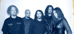 Sinisävyinen valokuva Chaoswave-nimisen bändin jäsenistä, joihin lukeutuu neljä miestä ja yksi nainen. He seisovat rivissä vaaleata taustaa vasten. Osalla heistä pitkät hiukset, yhdellä miehistä kalju pää.