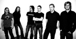 Mustavalkoinen valokuva Fall of the Leafe -yhtyeen kuudesta jäsenestä, jotka seisovat rivissä valkoista taustaa vasten pukeutuneina lähinnä mustiin tai tummiin vaatteisiin. Osalla heistä pitkä heviletti, osalla lyhyeksi skraapatut hiukset.