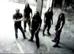 Nightrage-yhtyeen viisi jäsentä, jotka pukeutuneet mustiin vaatteisiin, seisovat jonkinlaisessa katoksessa tai varastohallissa, jossa lattia on vaaleaa betonia. Osalla miehistä pitkät mustat hiukset, yhdellä vaalea lyhyt letti.