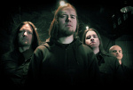 Neljä mustiin pukeutunutta Insomnium-metallibändin jäsentä, jotka ovat miehiä, seisovat rivissä tummaa taustaa vasten. Etummaisena ja keskimmäisenä seisovalla hepulla pitkät vaaleat hiukset ja leukapartaa.