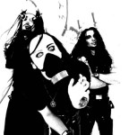 Mustavalkoinen valokuva kolmesta The Kovenantin miesjäsenestä, jotka poseeraavat ylivalottuneessa bändikuvassa. Keskimmäisellä kasvojensa edessä musta happimaski ja silmät näyttävät olevan jotenkin eriskummalliset.