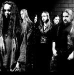 Mustavalkoinen bändikuva Shape of Despair -nimisen metalliyhtyeen jäsenistä. Kuvassa viisi miestä ja yksi nainen, joka seisoo joukon keskimmäisenä. Kaikilla heillä pitkät hiukset. He seisovat tiiliseinää vasten.